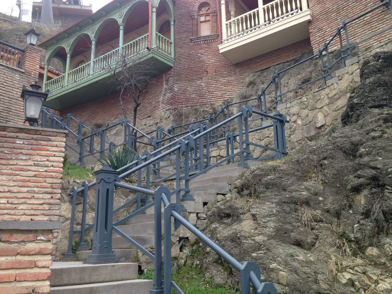 The iron-railed Betlemi stairs climbing past brick houses and carved wooden balconies in old Tbilisi.